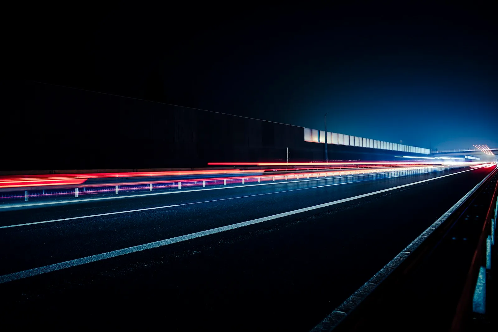 Estelas de luz de vehículos en una autopista de noche